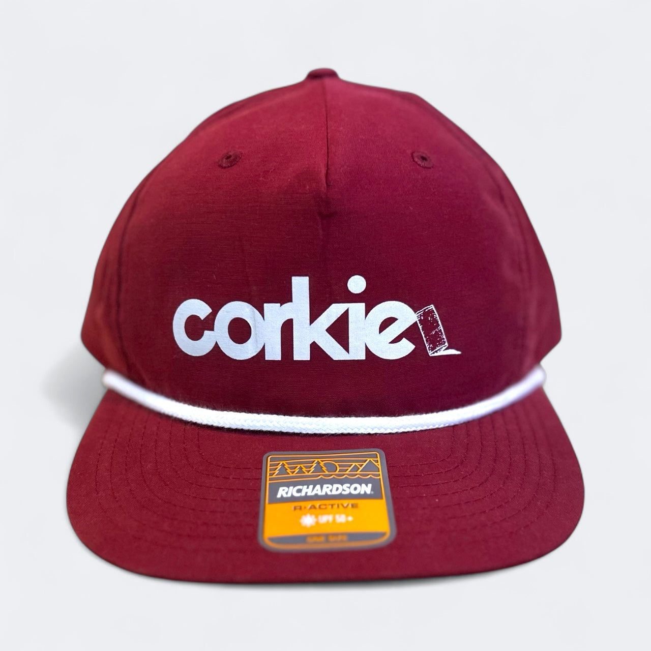 Maroon cap with 'corkie' wine lovers logo and Richardson label on a light gray background